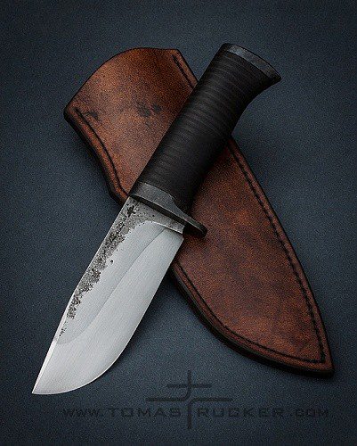 Bushcraft knife with hamon line and stacked leather washer handle by Tomas TRMAN Rucker.